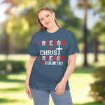 Person wearing a blue t-shirt with text and a cross graphic park background