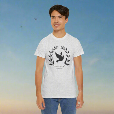 Person wearing a gray t-shirt with a black frond of leaves and dove