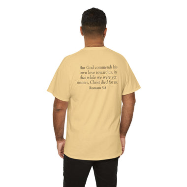 Man wearing a yellow t-shirt with text of Romans 5:8 on the back, standing against a white background