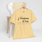 Yellow t-shirt with 'Forgiven & Free' text on a wooden hanger hung on chair against a white background